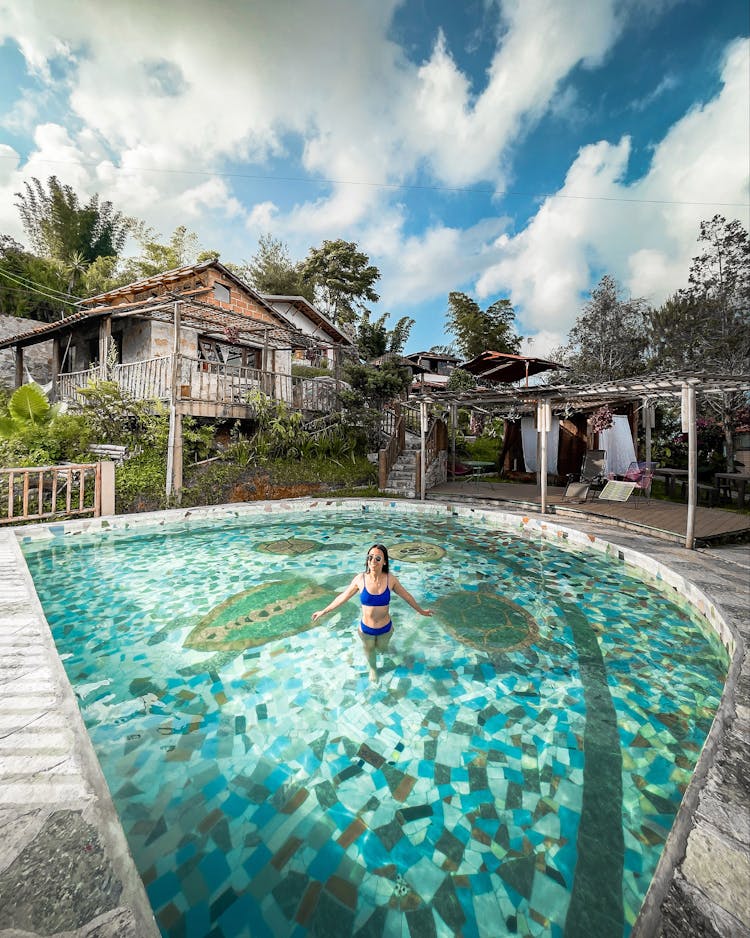 A Woman In A Swimming Pool With Mosaic Tiles