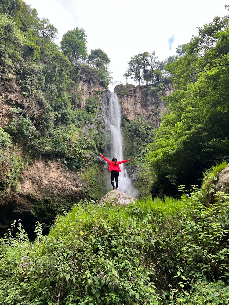 Woman Standing By The Waterfall 