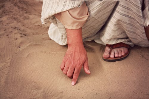 Person, Die Weißes Und Graues Gestreiftes Kleid Trägt, Das Braunen Sand Berührt