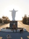 People Sitting on Bench Near Statue of Man and Woman