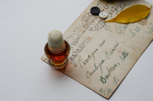 Close-Up Shot of a Vintage Paper beside a Bottle