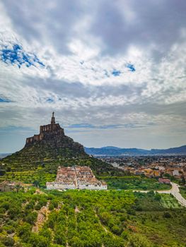 Aerial view of the Monteagudo Castle atop a hill with surrounding greenery and cityscape in Murcia, Spain.