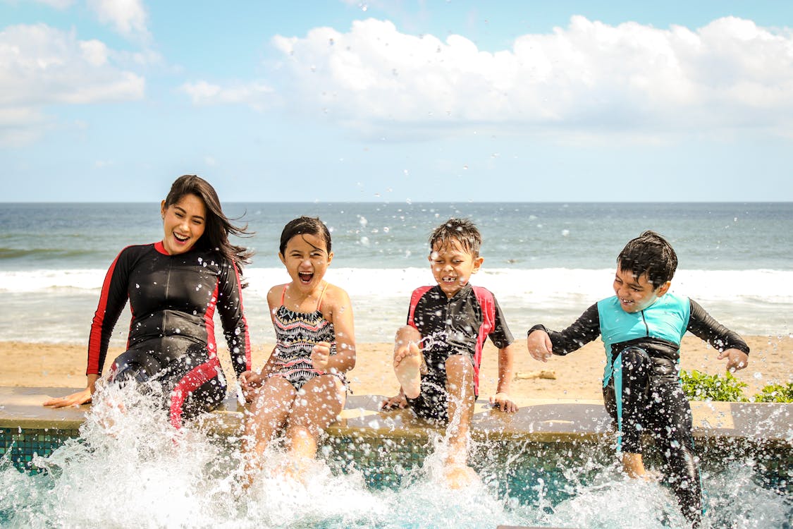 Mujer Y Tres Niños Jugando Al Agua