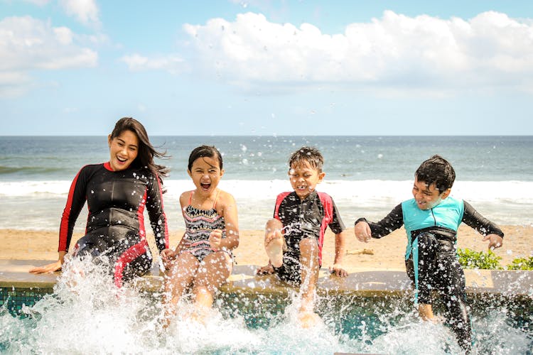 Woman And Three Children Playing Water