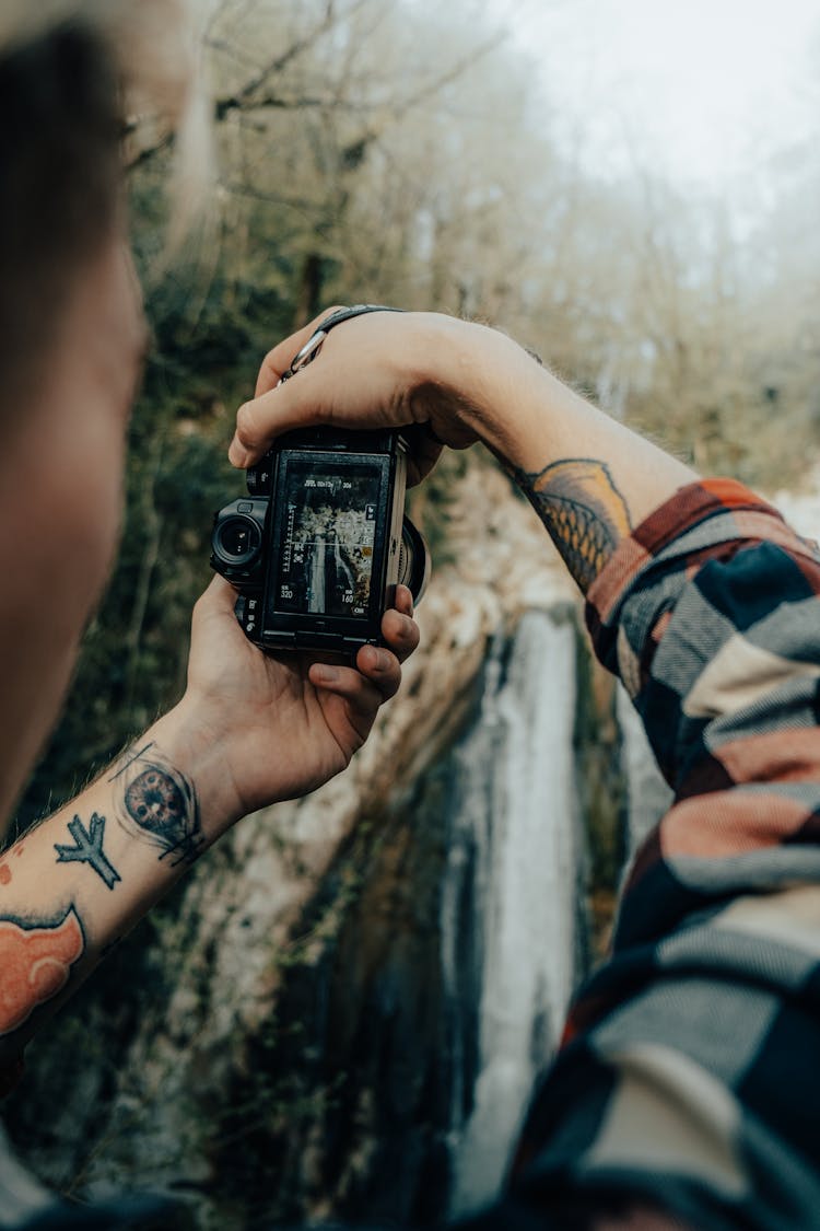 Man Taking Pictures In Autumn Woods