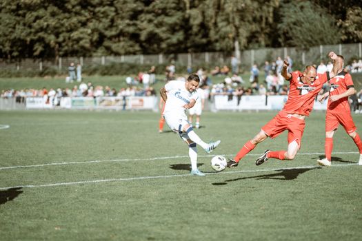 Exciting soccer match with athletes competing on a sunny field, showcasing action-packed gameplay.