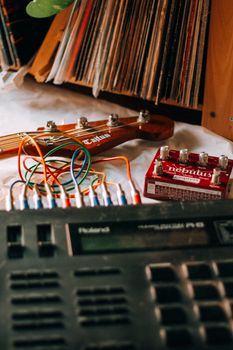 Close-up of electronic music gear with a guitar neck and colorful cables, ideal for music production themes.