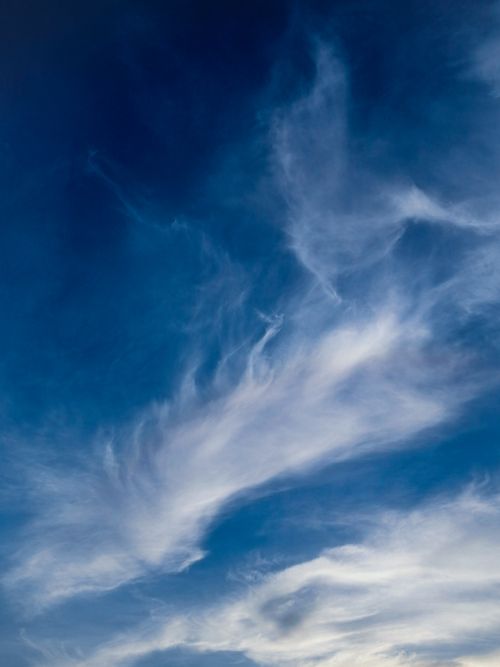 Free A tranquil view of wispy white clouds against a vibrant blue sky, showcasing nature's beauty. Stock Photo