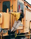 Teenage Girl Posing on an Orange Locomotive