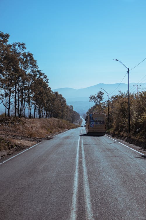 Bus Traveling on Asphalt Road