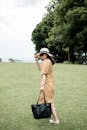 Woman in a Beige Dress Walking Through a Green Park