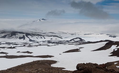 Free Dramatic snowy landscape featuring a distant volcano under a cloudy sky. Stock Photo