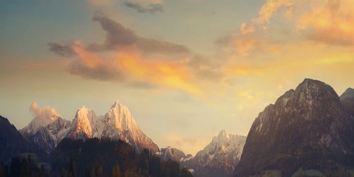 Breathtaking view of snowcapped mountains under a beautiful sunset sky.