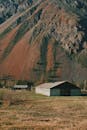 Photo of a Building and a Field near the Mountain