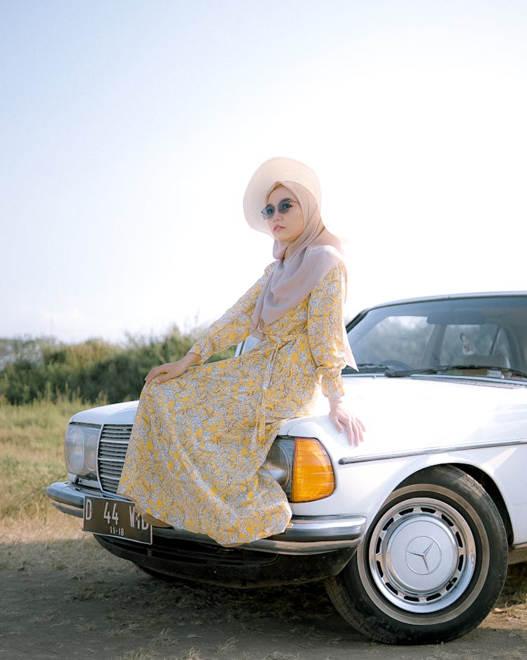 Woman Sitting On The Hood Of A Car