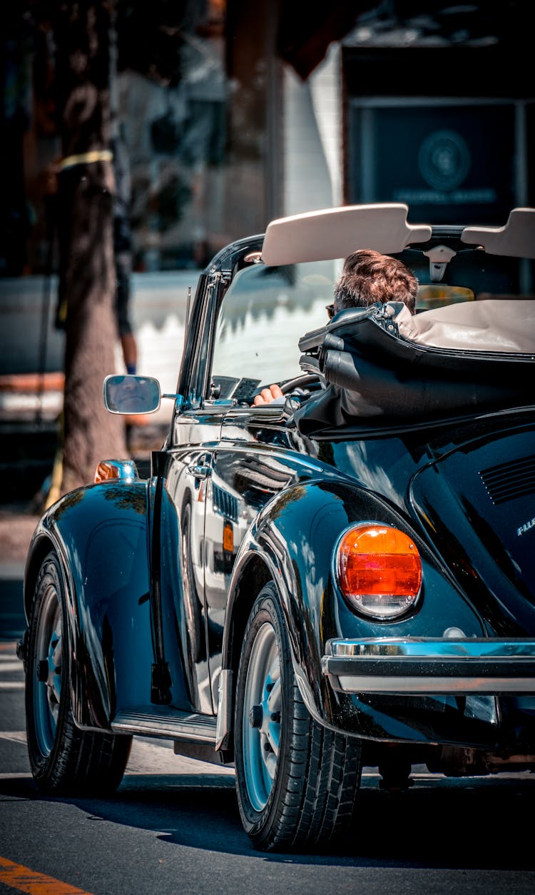 Back View Of A Person Driving A Convertible Car