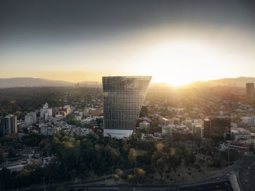 Free Aerial view of Mexico City skyline at sunset, featuring a distinctive modern building. Stock Photo