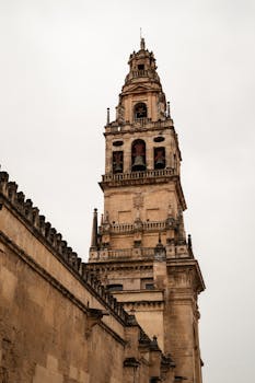 Majestic view of the historic bell tower in Córdoba, Spain, showcasing Baroque and Islamic architecture.