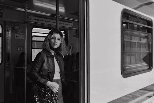 Grayscale Photo of Woman Inside the Train