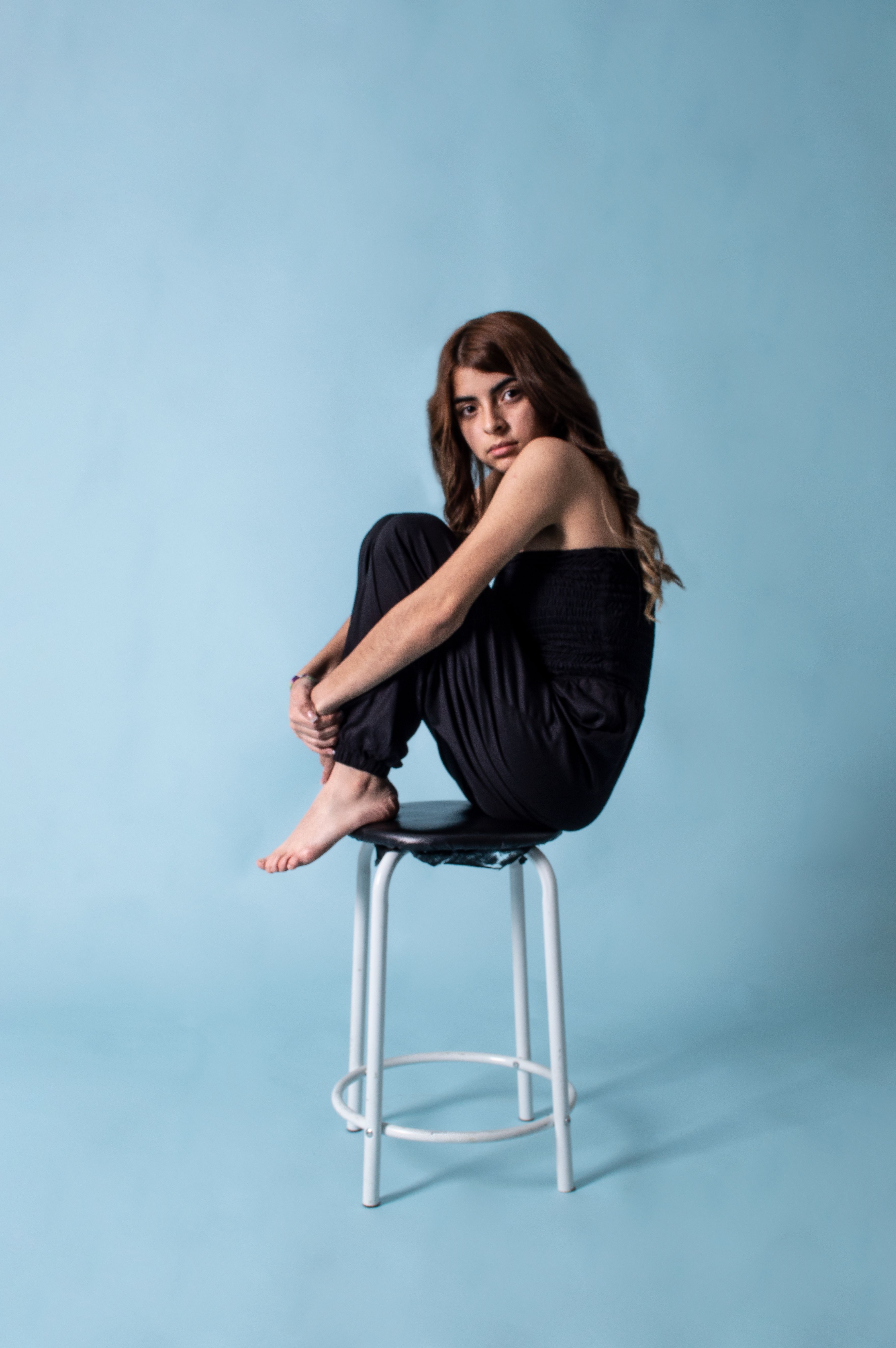 A Woman in Blue Jeans Sitting on a Chair · Free Stock Photo