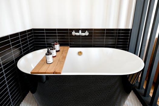 Elegant modern bathroom with freestanding tub and black tile design.