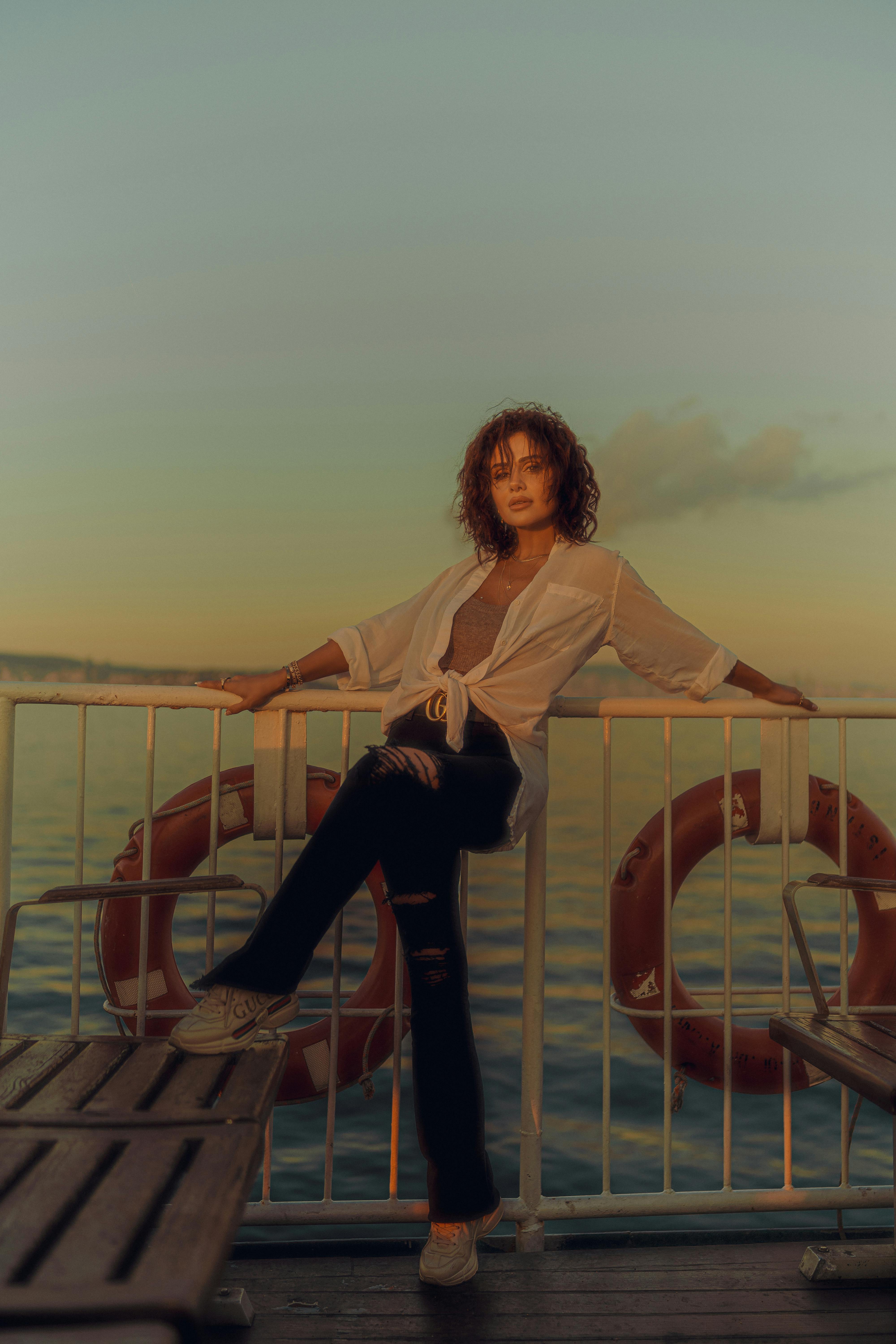 A woman poses on a boat deck during a calming sunset cruise.