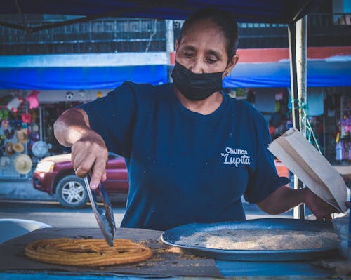 Woman Making Churros on a Street Market 