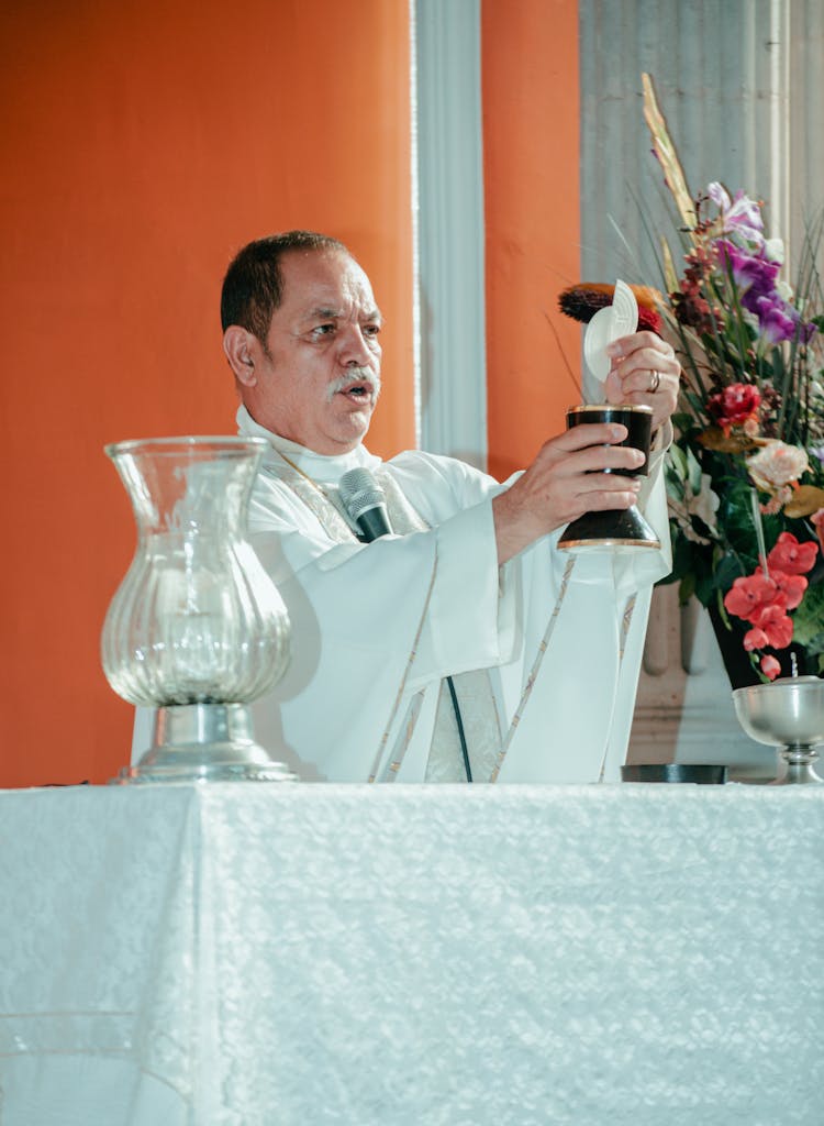 Priest During A Mass Holding The Host