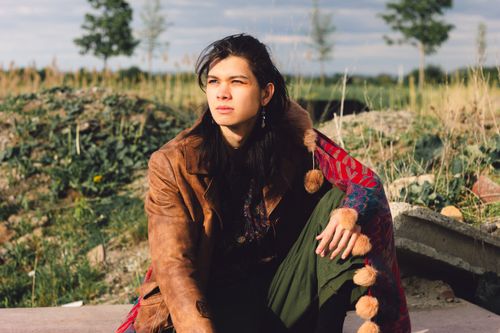 Free A fashionable young adult posing confidently in a natural outdoor setting, showcasing a stylish outfit. Stock Photo