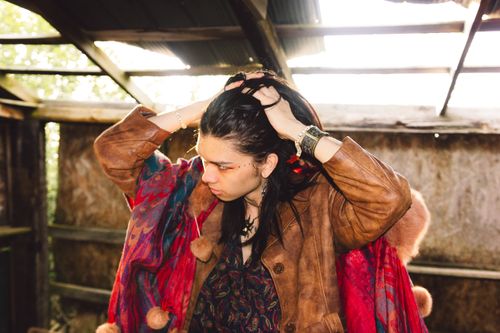 Free A fashionable young adult standing indoors, wearing a boho chic outfit with vibrant colors. Stock Photo