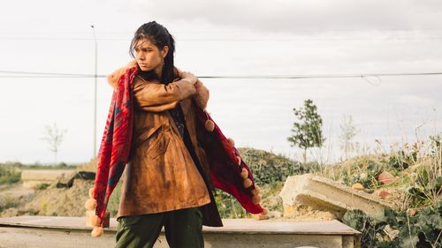 Free Woman in vintage leather coat with red shawl in an outdoor setting. Fashion and style outdoors. Stock Photo