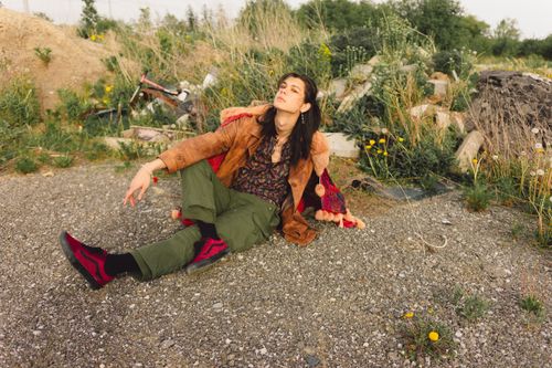 Free Stylish young adult in a bohemian outfit poses in a natural outdoor setting, exuding a relaxed and fashionable vibe. Stock Photo