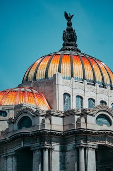 Brightly colored dome of the Palacio de Bellas Artes in Mexico City against a clear blue sky.