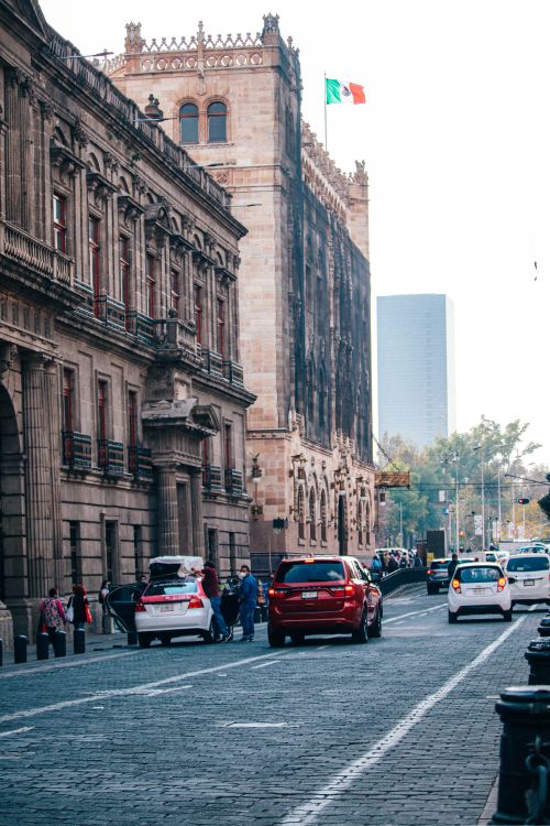 Free Busy street scene in Mexico City with historic architecture and vehicles lining the pavement. Stock Photo