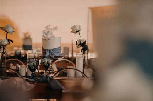 Free Romantic table setting with white roses, candles, and elegant glassware at a wedding reception. Stock Photo