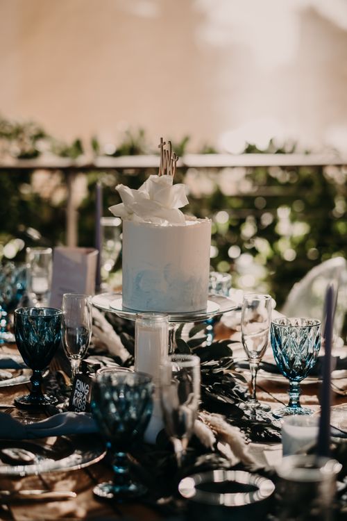 Free A beautifully decorated white cake on a festive tablescape outdoors, perfect for celebrations. Stock Photo