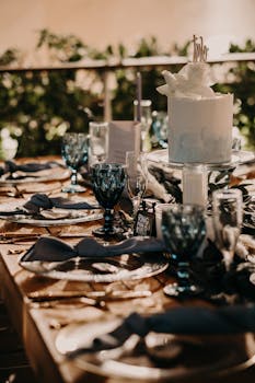 Chic outdoor wedding table setting with elegant cake and tableware.