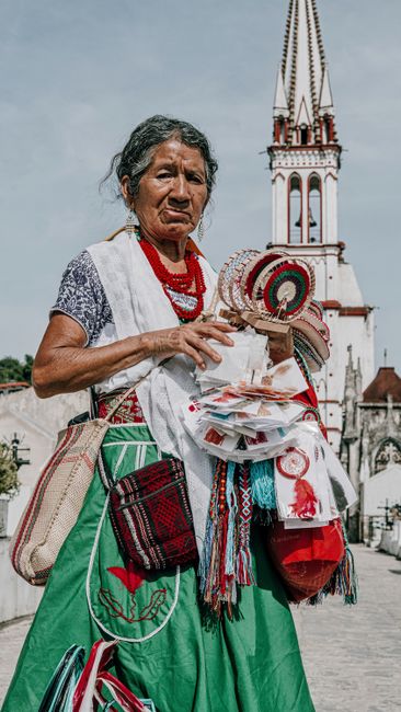 Portrait of a Mexican street vendor in traditional attire selling handmade souvenirs in Cuetzalan.