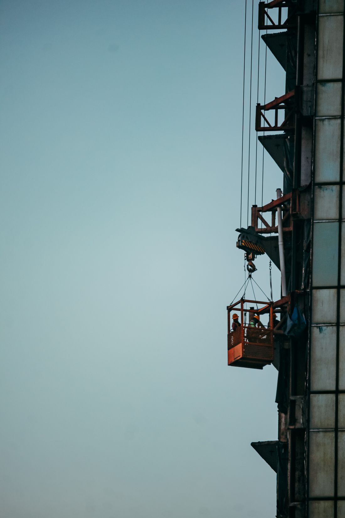 Workers erecting a tower crane at height