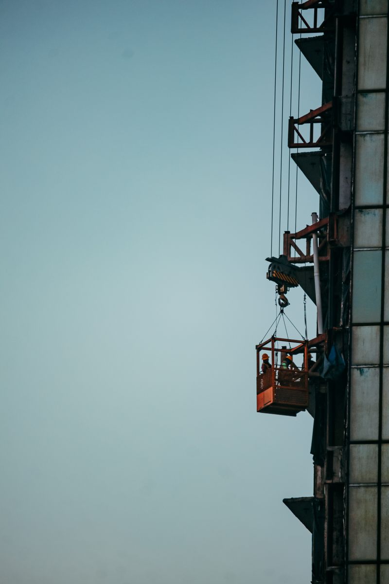 Workers erecting a tower crane at a high-rise site