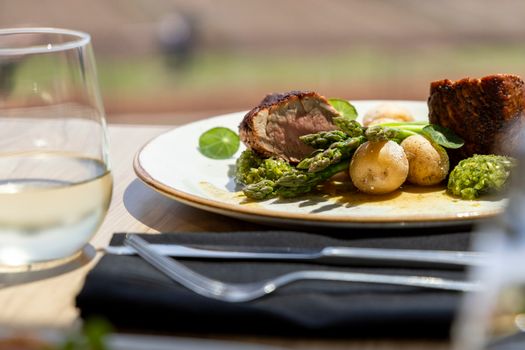 Close-up of a gourmet meal featuring asparagus, potatoes, and meat for a fine dining experience.