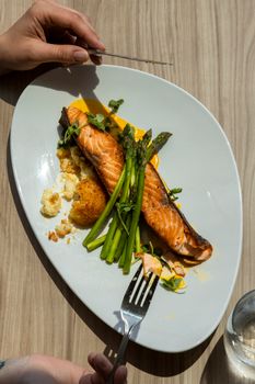 Delicious grilled salmon served with asparagus and garnished vegetables on a modern plate.