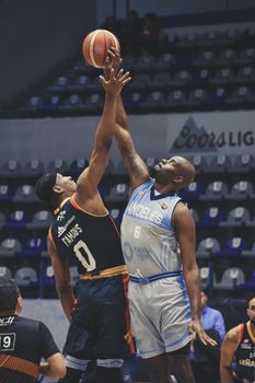 Basketball players jump for tip-off during a game in Puebla, Mexico.