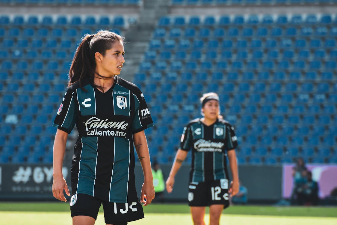 Free Two Women in Black and White Jersey Uniforms Standing on a Field Stock Photo