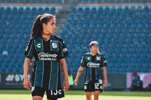 Two Women in Black and White Jersey Uniforms Standing on a Field