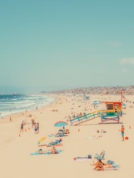 Vibrant beach scene at Hermosa Beach, California with people enjoying sunny leisure activities.