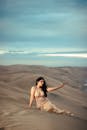 Woman Sitting on Sand Dune 