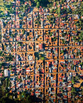 Aerial view of a residential neighborhood with a grid layout and colorful rooftops.