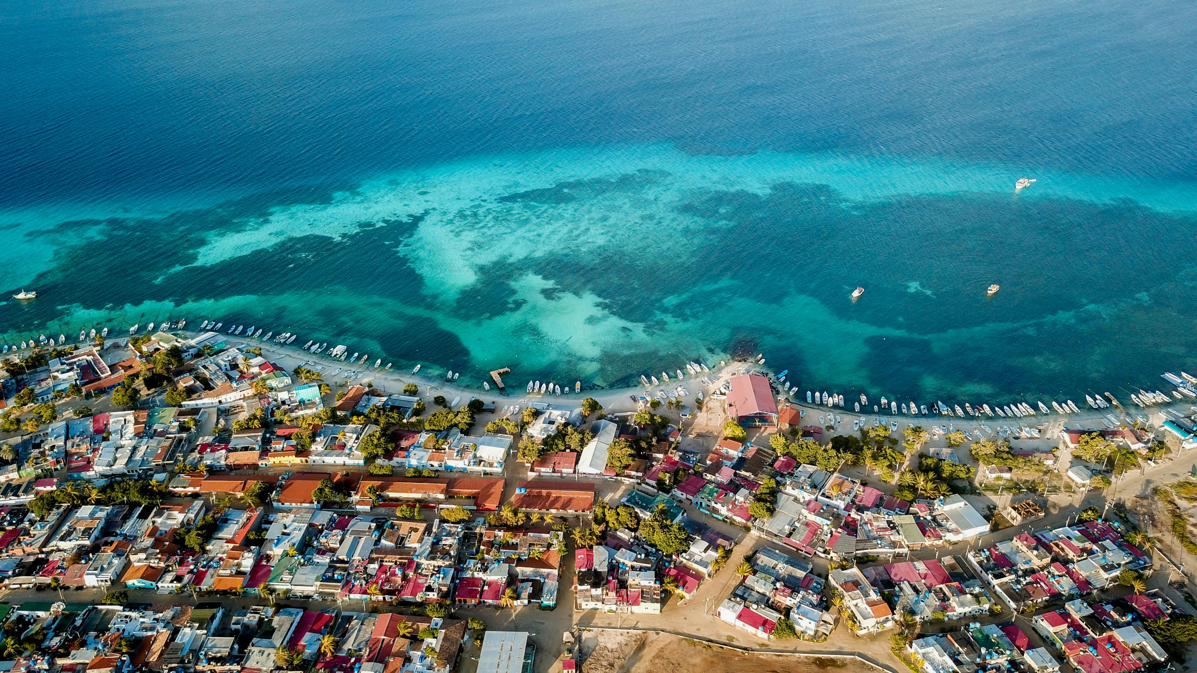 A stunning aerial view of a vibrant coastal city and deep blue sea in Venezuela.