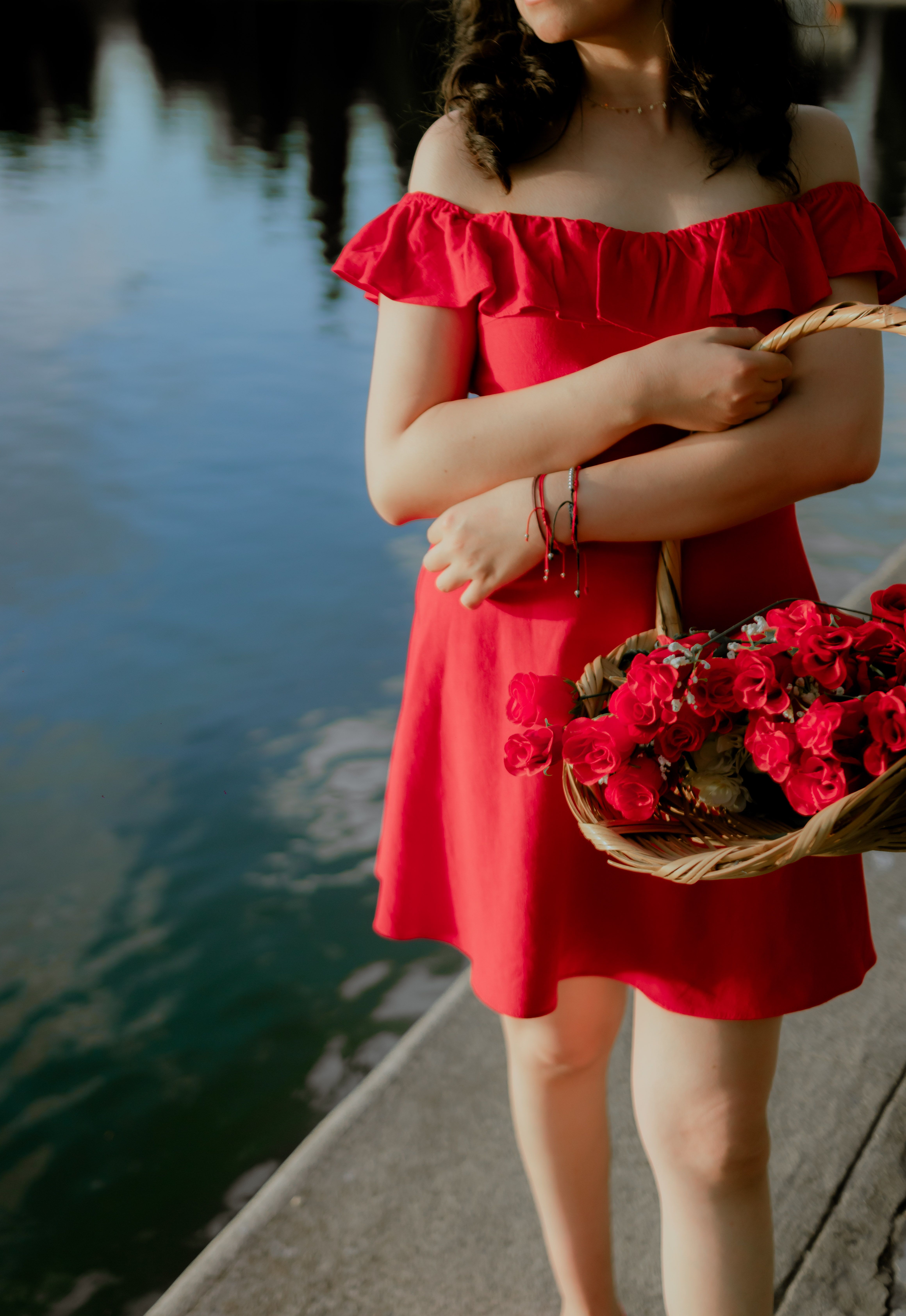 A Woman in Red Dress Holding Basket near Body of Water · Free Stock Photo